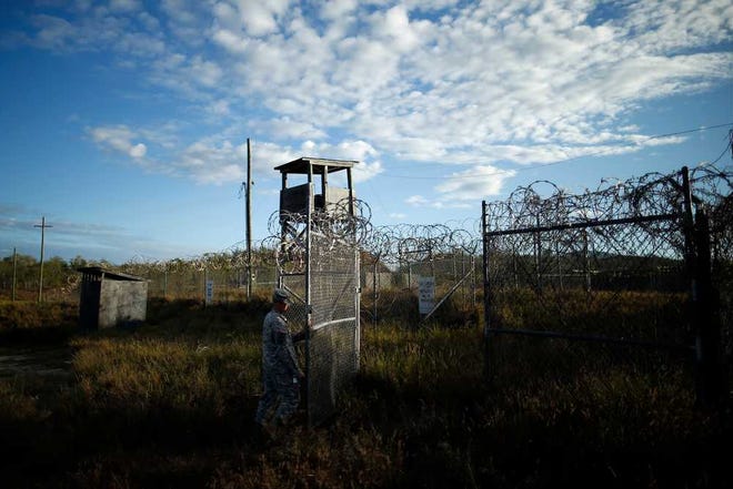 FILE - In this Nov. 13, 2013, file photo reviewed by the U.S. military, a soldier closes the gate at the now abandoned Camp X-Ray, which was used as the first detention facility for al-Qaida and Taliban militants who were captured after the Sept. 11 attacks at Guantanamo Bay Naval Base, Cuba. During six years behind bars at Guantanamo Bay, Abdul Rauf insisted he was a lowly Taliban foot soldier, even though he was really a corps commander. Rauf was released in 2007 and sent home to Afghanistan. He was working as the top recruiter in Afghanistan for Islamic State militants when a drone strike on Feb. 9, 2015, killed him along with seven others. (AP Photo/Charles Dharapak, File)