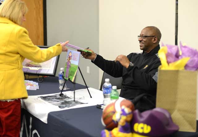 ECU coach Ruffin McNeill talks with Ann Law after signing copies of his children’s book, ‘A Little Pirate’s ABC’s’ on Tuesday at the Woodmen Community Center.