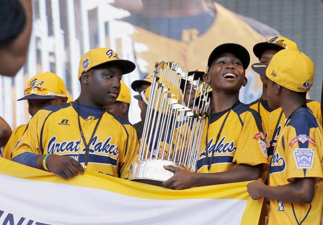 In this Aug. 27, 2014, file photo, members of the Jackie Robinson West Little League baseball team participate in a rally in Chicago celebrating the team's U.S. Little League Championship. Little League International has stripped the team of its national title after finding the team falsified its boundary map. (AP Photo/Charles Rex Arbogast, File)