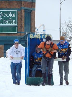 This 2014 file photo shows the LSSU Bass Club participating in the downtown Outhouse Races in Sault Ste. Marie.
