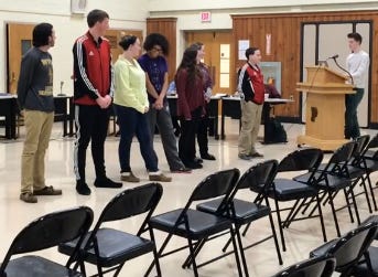 As Palmyra student council vice president John Kay asks the school board to relax the district's existing uniform policy, students display the kind of clothes they would wear to school during a meeting in Feburary 2013.
