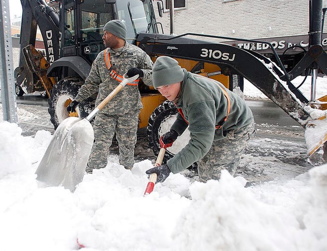 From left: Mike Jones and Chris Auld from 1a1Engineers unit of the National Guard dig out hydrants on Main Street in Brockton on Thursday Feb.12, 2015.
