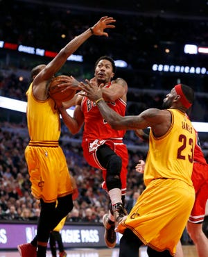 Chicago Bulls guard Derrick Rose (1) drives and scores past Cleveland Cavaliers' James Jones, left, and LeBron James during the second half of an NBA basketball game Thursday, Feb. 12, 2015, in Chicago. The Bulls won 113-98.