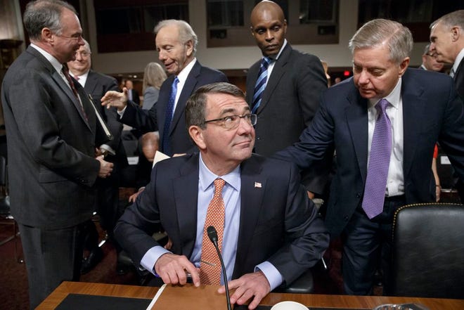 Ashton Carter, President Barack Obama's choice to be defense secretary, is greeted by Sen. Lindsey Graham, R-S.C., right, during a break in Carter's testimony before the Senate Armed Services Committee as the panel considers his nomination to replace Chuck Hagel as Pentagon chief, Wednesday, Feb. 4, 2015, on Capitol Hill in Washington. Carter, who previously served as the No. 2 Pentagon official, has won Senate confirmation. At far left is Sen. Tim Kaine, D-Va., speaking with former Connecticut Sen. Joe Lieberman, third from left. (AP Photo/J. Scott Applewhite)