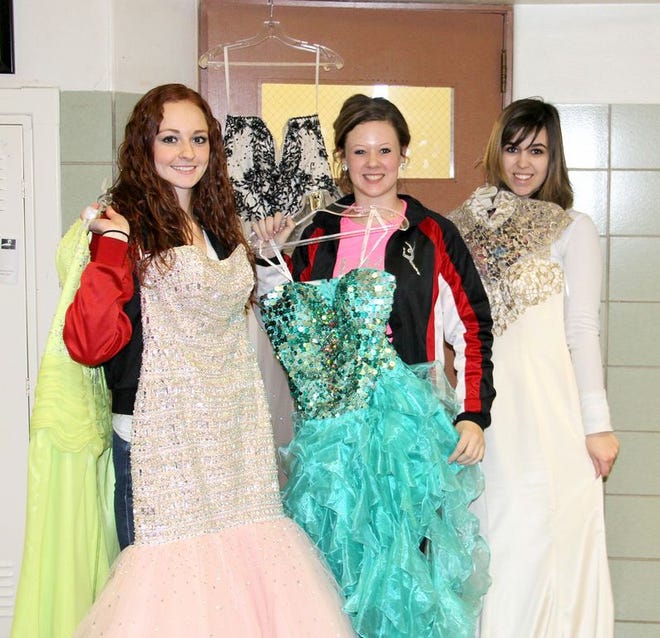 Student Council Secretary Anna Oelschlager, left, along with Council Member Lilly Esterline and Council President Kassidy Kimpling compare dresses set for inventory.