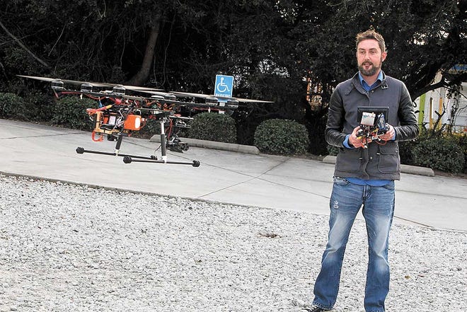 Chris Rackley, owner of Lewis Realty Associates, Inc. in Surf City, flies his custom-built drone outside of his office recently. Rackley is trying to get the drone approved for commercial use.