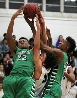Ashbrook's Austin Mitchell and Isaiah Whaley battle for a rebound with Hunter Huss' Leroy Barnett during their game Friday night.