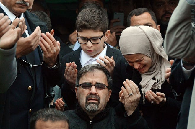 Namee Barakat, center, watches during funeral services for his son, Deah Shaddy Barakat, Thursday, Feb. 12, 2015, in Wendell, N.C. Barakat, 23, his wife, Yusor Mohammad Abu-Salha, 21, and her sister Razan Mohammad Abu-Salha, 19, were found dead Tuesday at their home near the University of North Carolina-Chapel Hill campus. Charged with three counts of first-degree murder is Craig Stephen Hicks. (AP Photo/The News & Observer, Chuck Liddy)