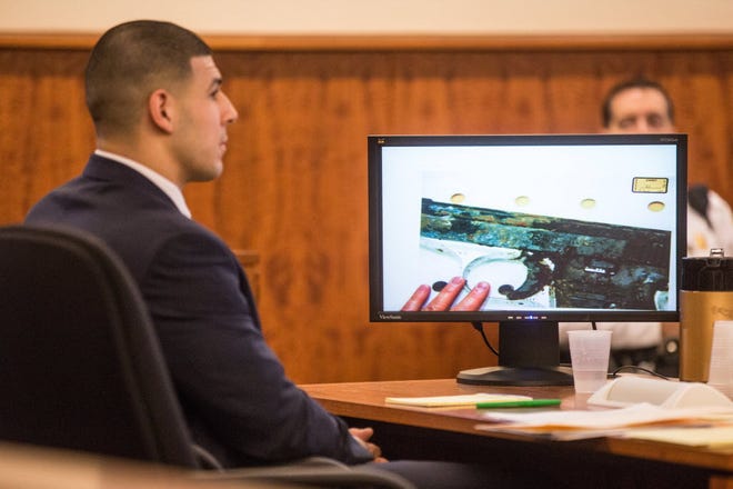 Aaron Hernandez listens to testimony as a photo of a small handgun found in a wooded area near where Odin Lloyd was shot to death  is displayed during his murder trial on Friday in Fall River, Mass.

Associated Press