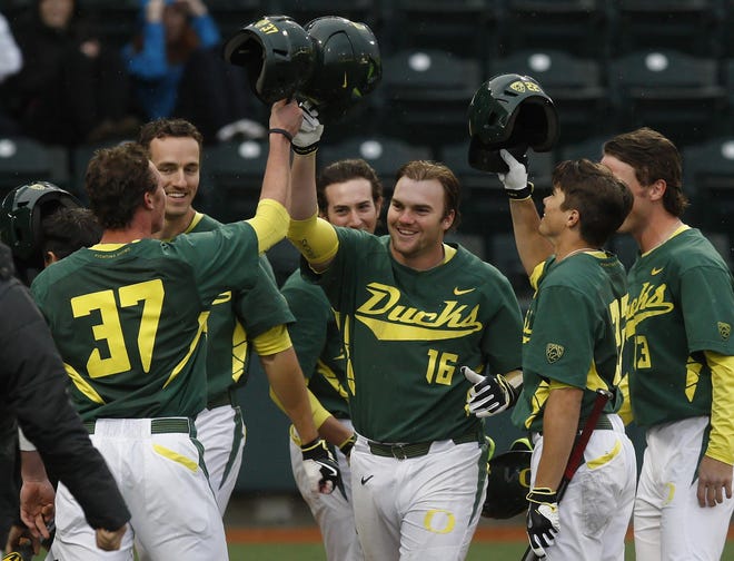 The Ducks Shaun Chase, 16, is met by teammates at home plate after Chase hit a grand slam to put the Ducks up 5-1 over the Wildcats on Sunday at PK Park. (Collin Andrew/The Register-Guard)