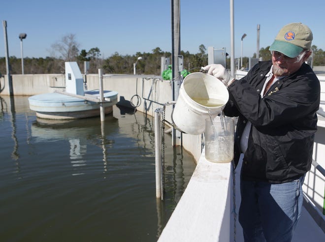 Allyn Burgess, chief operator, demonstrates how he checks the clarity of the water at the North Bay Wastewater Treatment Facility last month.