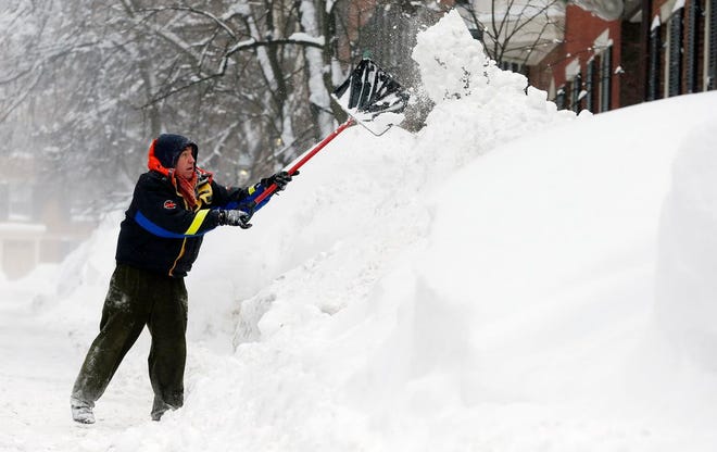 Brian Vallely shovels snow on Beacon Hill in Boston, Sunday, Feb. 15, 2015. A blizzard warning was in effect for coastal areas from Connecticut to Maine on Saturday for a fourth major storm in less than a month, promising heavy snow and powerful winds to heap more misery on a region that has already seen more than 6 feet of snow in some areas. (AP Photo/Michael Dwyer)