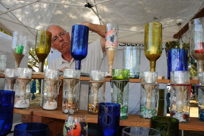 Bottle artist Tim Schoonard of Altoona shows candle holders made from cut wine bottles that hang upside down. He was among more than 80 artists and crafters at the Winefest XXV at Lakeridge Winery and Vineyards in Clermont over the weekend.