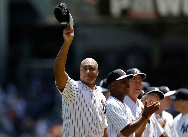 FILE - This June 23, 2013 file photo shows former New York Yankees outfielder Bernie Williams waving his cap as he is introduced before the Yankees Old Timers Day baseball game at Yankee Stadium in New York. The Yankees are retiring the uniform numbers of Andy Pettitte, Jorge Posada and Bernie Williams and will honor the trio with plaques in Monument Park this season along with Willie Randolph. Williams will be honored before the May 24 game against Texas. (AP Photo/Kathy Willens, file)