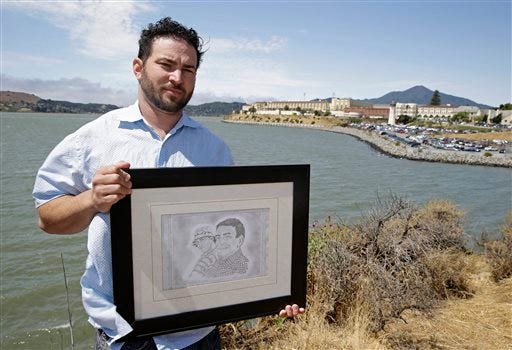 In this Tuesday, July 8, 2014 photo, Dan Ager holds a graphite sketch showing his father, Alan Ager, and him, while standing outside San Quentin State Prison in San Quentin, Calif. Alan Ager was killed in 2010 at Salinas Valley State Prison and also served time in San Quentin. California state prison inmates are killed at a rate that is double the national average, and sex offenders like Alan Ager account for a disproportionate number of victims, according to an Associated Press analysis of corrections records. (AP Photo/Eric Risberg)