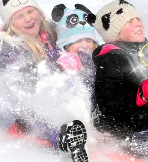 Jamie Treiver, left, Carrie Warner and Camdyn Lockley enjoy a sled ride at Jim Barnett Park, Tuesday, Feb. 17, 2015 in Winchester, Va. A winter storm blasted parts of the Mid-Atlantic and the South on Tuesday, creating treacherous road conditions and leaving hundreds of thousands without power. (AP Photo/The Winchester Star, Jeff Taylor)