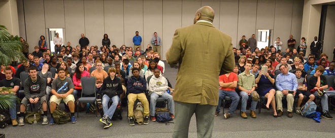 PETER.WILLOTT@STAUGUSTINE.COM Author Stephanie Perry Moore holds one of her books while talking to students from First Coast Technical High School during an assembly on Tuesday, Feb. 17, 2015.