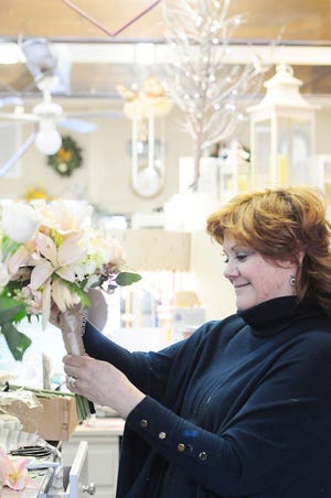 Patti Kuhn, owner of Posies by Patti works on a hand held abstract boquet in blush champagnes for the prom show that is going to be held at Riverside High School Wednesday evening from 6-8. Posies by Patti is one of the 14 businesses that will be featured at the event.