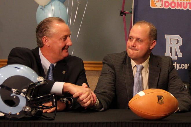 URI athletic director Thorr Bjorn, right, welcomes football coach Jim Fleming to URI in 2013.
