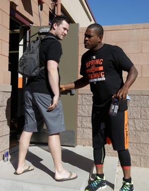San Francisco Giants catcher Andrew Susac, left, talks with relief pitcher Santiago Casilla after arriving for spring training baseball workouts Wednesday, Feb. 18, 2015, in Scottsdale, Ariz. (AP Photo/Darron Cummings)