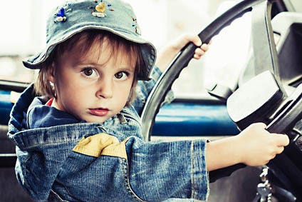 Little kid playing at the wheel of car