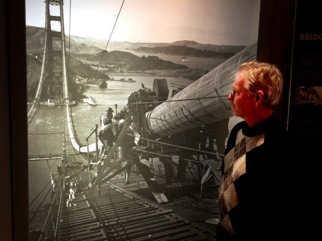 John Seitter, Roebling Museum executive director, looks at a photo of cables being installed on the Golden Gate Bridge.