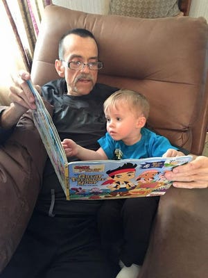 Matt Weil and his grandson look at a book together.