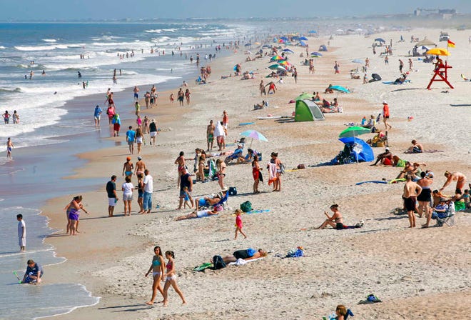 DARON.DEAN@STAUGUSTINE.COM Beachgoers pack St. Augustine beach, just south of the St. Johns COunty Fishing Pier.