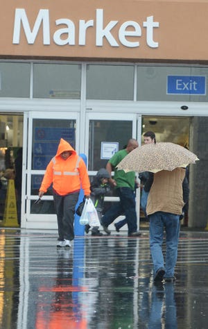 TIMES RECORD FILE PHOTO / Shoppers come and go at the Walmart Supercenter on Zero Street as rain and sleet begin to fall in Fort Smith in December 2013.
