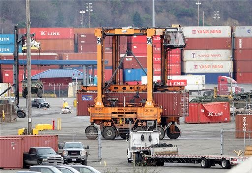 A cargo container is moved at the Port of Tacoma, Friday, Feb. 20, 2015, in Tacoma, Wash. With a Friday deadline looming, negotiators for the two sides in the contract dispute that has snarled international trade at U.S. West Coast seaports are laboring to reach a settlement as billions of dollars of cargo are sitting massive ocean-going ships anchored outside port facilities. (AP Photo/Ted S. Warren)