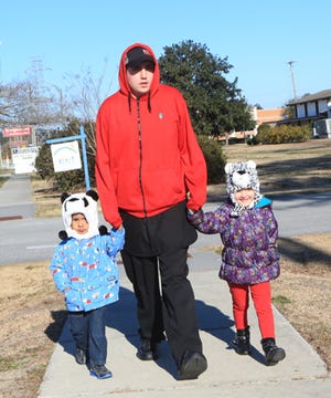 Fitzgerald Mendez walks his daughter Ariana Rivera, 4, and son Julius Mendez, 2, to day care along Gum Branch Road in Jacksonville on Friday morning as temperatures in the area hover in the teens.