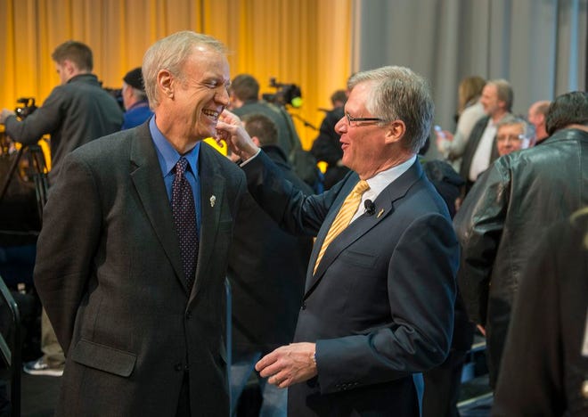 Illinois Governor Bruce Rauner, left, laughs with Caterpillar, Inc. CEO Doug Oberhelman Friday at the Caterpillar Visitor Center.
