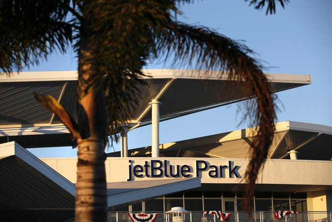 A palm tree frames the jetBlue Park sign at the top of the Boston Red Sox's baseball spring training facility in Fort Myers on Friday. Red Sox pitchers and catchers begin workouts Saturday.