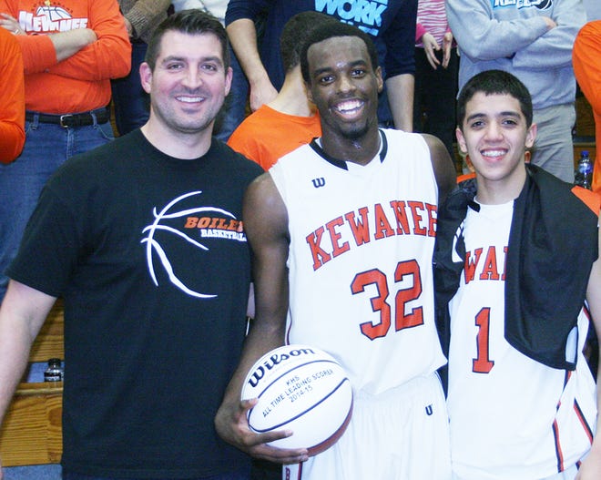 Kewanee junior Donovan Oliver, center, scored 38 points and broke the school’s all-time scoring record Friday night. Matt Salisbury, left, held the record with 1,634 points and presented Oliver with a basketball recognizing the new mark of 1,643 points. Oliver’s teammate Tanner Arzola, right, joined the presentation.