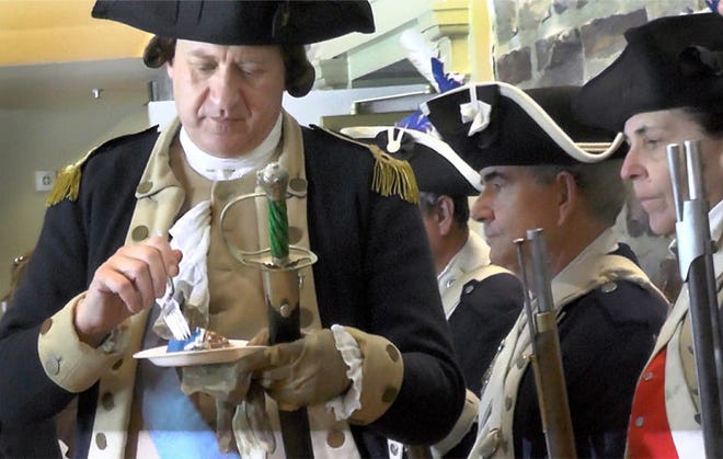 John Godzieba portraying Gen. George Washington takes a taste of his birthday cake on his 283rd birthday at Washington Crossing Visitor Center in Upper Makefield on Sunday.