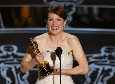 Julianne Moore accepts the Oscar for Best Leading Actress for her role in “Still Alice” at the 87th Academy Awards in Hollywood, California February 22, 2015. 
 Actor Eddie Redmayne reacts as he takes the stage to accept the Oscar for best actor for his role in “The Theory of Everything” during the 87th Academy Awards in Hollywood, California February 22, 2015. REUTERS/Mike Blake