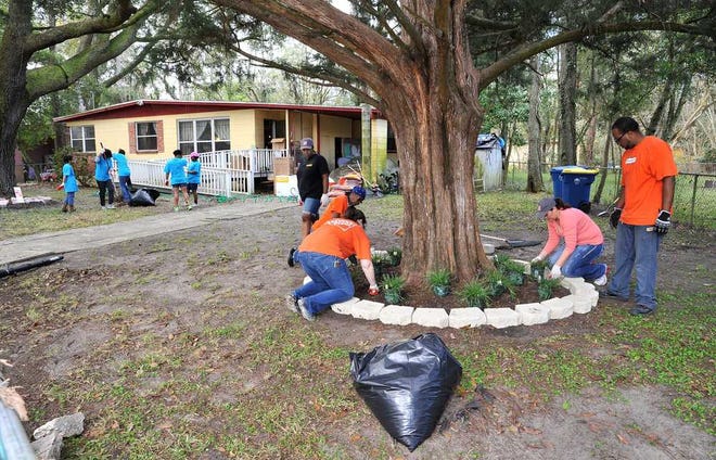 Photos by Bruce.Lipsky@jacksonville.com Volunteers from The Home Depot and other groups spruce up the yard of 114-year-old Blanche Cobb on Monday. The groups were also doing some repairs and upgrades to her home.