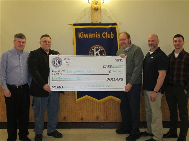 Edward Banzy, treasurer for The Dwelling Place in Woburn, receives a donation from Michael Rice, Kiwanis Board member; and Phil Minghella, president of the Woburn Kiwanis Club. Also pictured are Mike Capeless and Mike Capeless, Jr. Courtesy Photo