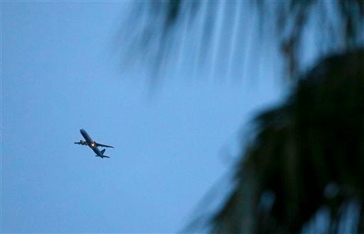 Framed by neighborhood palm trees, a passenger plane brings increased noise to residential neighborhoods like this one near Phoenix as new FAA flight routes out of Phoenix Sky Harbor International Airport are affecting dozens of neighborhoods with the new noise that residents previously did not have to be subjected to Friday, Feb. 20, 2015, in Laveen, Ariz. (AP Photo/Ross D. Franklin)