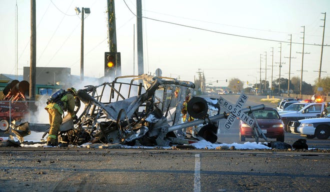 A firefighter stands near the burned wreckage of a truck that was hit by a Metrolink train that then derailed at a train crossing Tuesday in Oxnard, Calif. Three cars of the Metrolink train tumbled onto their sides, injuring dozens of people in the town 65 miles northwest of Los Angeles.