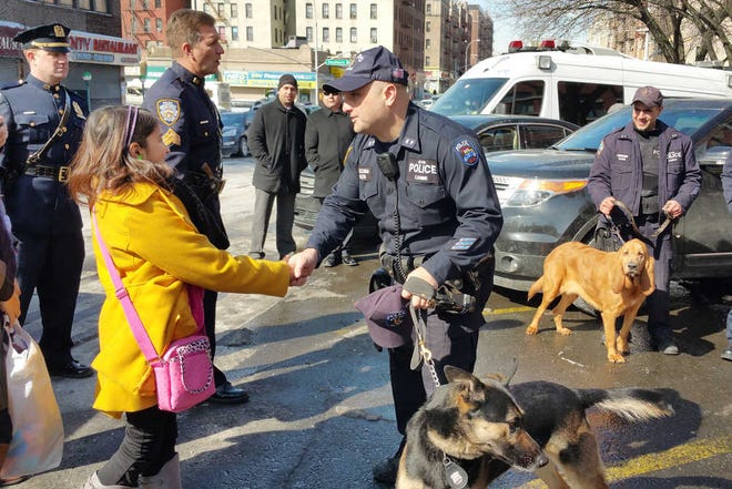 Savannah Solis, left, is greeted by a New York City police officer while visiting a police precinct in the Bronx, Tuesday, Feb. 24, 2015. The 10-year-old girl from Tyler, Texas sent hundreds of thank you cards to the NYPD after two officers were fatally shot in Brooklyn. She told the officers she wants to thank them "for what they do for us." (AP Photo/Verena Dobnik)