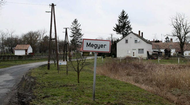 A signpost at the entrance to the village of Megyer, Veszprem county, 190 kilometers southwest of Budapest, Hungary, Wednesday, Feb. 25, 2015. The village of Megyer, population 18, has put itself up for rent to companies and tourists. For 210,000 forints ($750; 690 euro) a day, a prospective renter gets seven guesthouses that sleep 39 people, four streets, a bus stop, a barn, a chicken yard, six horses, two cows, three sheep and four hectares (10 acres) of farmland - along with the possibility of temporarily being named deputy mayor. (AP Photo/MTI, Lajos Nagy)