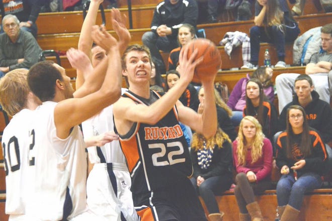 Rudyard's Zack Steikar (22) drives to the basket, while Sault seniors Terrance Fuller, Matt Eilola and Brendan Miller defend during a Straits Area Conference boys basketball game Tuesday night.