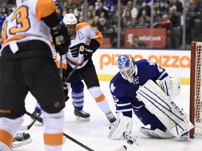 Maple Leafs goalie Jonathan Bernier makes a save as the Flyers' Wayne Simmonds (center) and Jakub Voracek look for a rebound during Thursday's game in Toronto.