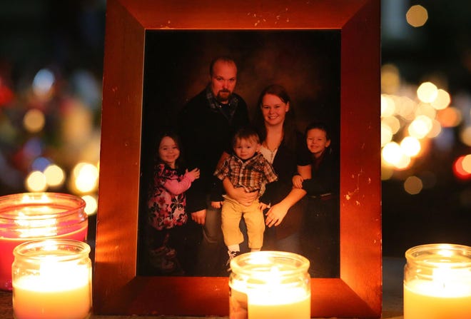 A family portrait sits at the impromptu memorial at the site during the vigil, where the children’s father briefly spoke. (Brian Davies/The Register-Guard)
