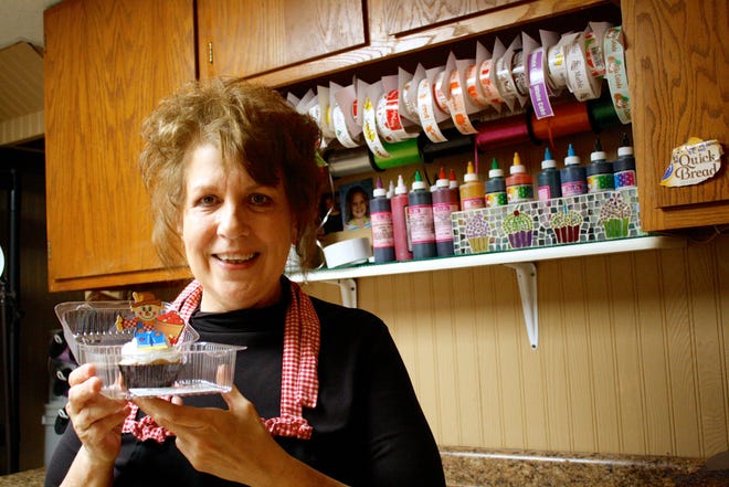 Cathy Koester shows off one of her custom cupcakes at Cathy’s Custom Cakery on Tuesday, Sept. 30, 2014.