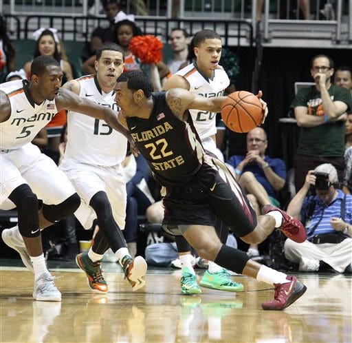In this Wednesday, Feb. 25, 2015, photo, Florida State University NCAA college basketball player Xavier Rathan-Mayes tries to drive against the defense of University of Miami Davon Reed (5) and Angel Rodriguez (13) in the final seconds of the second half against Miami in Coral Gables, Fla. With his team desperate for baskets, Xavier Rathan-Mayes couldn't miss. He scored 30 points in the final 4:38, and even that wasn't enough to beat the Miami Hurricanes.
