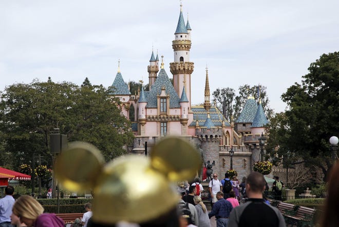 In this Jan. 22, 2015 file photo, visitors walk toward the Sleeping Beauty's Castle in the background at Disneyland Resprt in Anaheim, Calif. Visiting Mickey and Minnie just got more expensive. The Walt Disney Co. says it has raised ticket prices to attend Disneyland, Walt Disney World and the rest of its U.S. theme parks, effective Sunday, Feb. 22, 2015. A one-day ticket for either Disneyland or California Adventure in Anaheim is now $99 for anyone 10 or older. That's up from $96. Other U.S. Disney theme parks have posted similar increases.