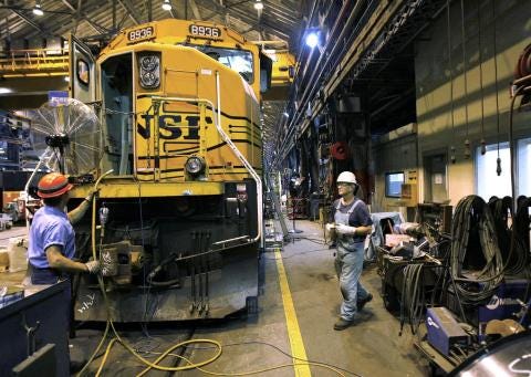 BNSF Railway employees work on putting an engine back together at the Topeka shops, where locomotives are overhauled. BNSF announced Thursday it will invest about $103 million into its railways for maintenance and expansions in Kansas in 2015.