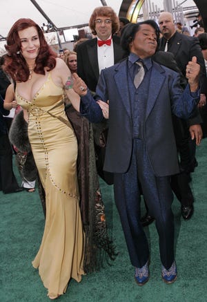 FILE- In this Feb. 13, 2005 file photo, James Brown arrives with his wife Tomi Rae Brown for the 47th Annual Grammy Awards in Los Angeles. A South Carolina judge approved a settlement Tuesday, May 26, 2009 for the estate of late soul singer James Brown. The settlement gives nearly half of the estate to Brown's charitable trust, about a quarter to his wife and young son, and the rest to Brown's adult children. (AP Photo/Mark J. Terrill, File)
